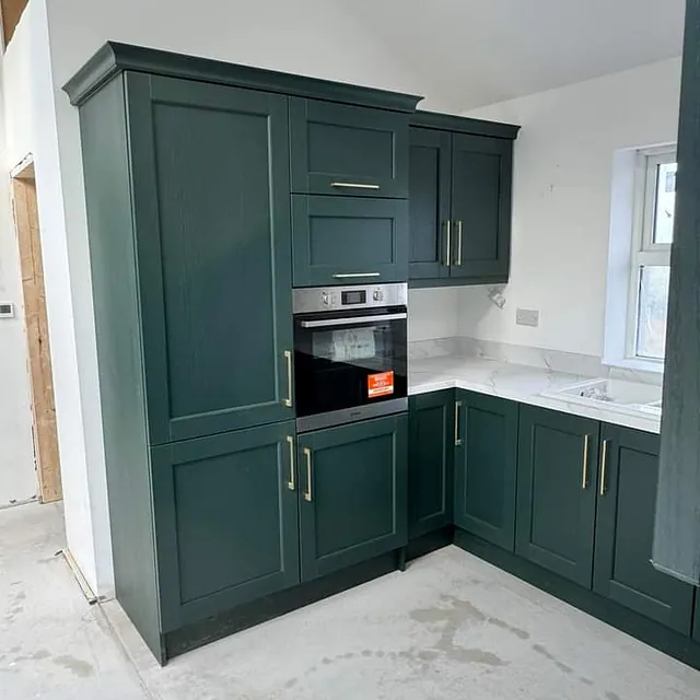 A  kitchen recently supplied by Strabane Wholesale Ltd and installed by Inside Out Creations consisting of a Bastille Evergreen Shaker Door,  Kensington brushed brass D handles, 40mm Square Edge Calacatta Olympus Worktop,  matching upstands & Splashback, Prima 1½ Bowl Ceramic Sink, Indesit Single Oven . A custom pantry unit in the utility room finishes the look.  Beautiful!!!!!